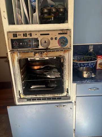 a stove top oven sitting inside of a kitchen