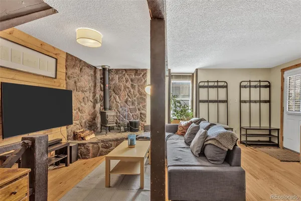a living room with furniture a flat screen tv and floor to ceiling window