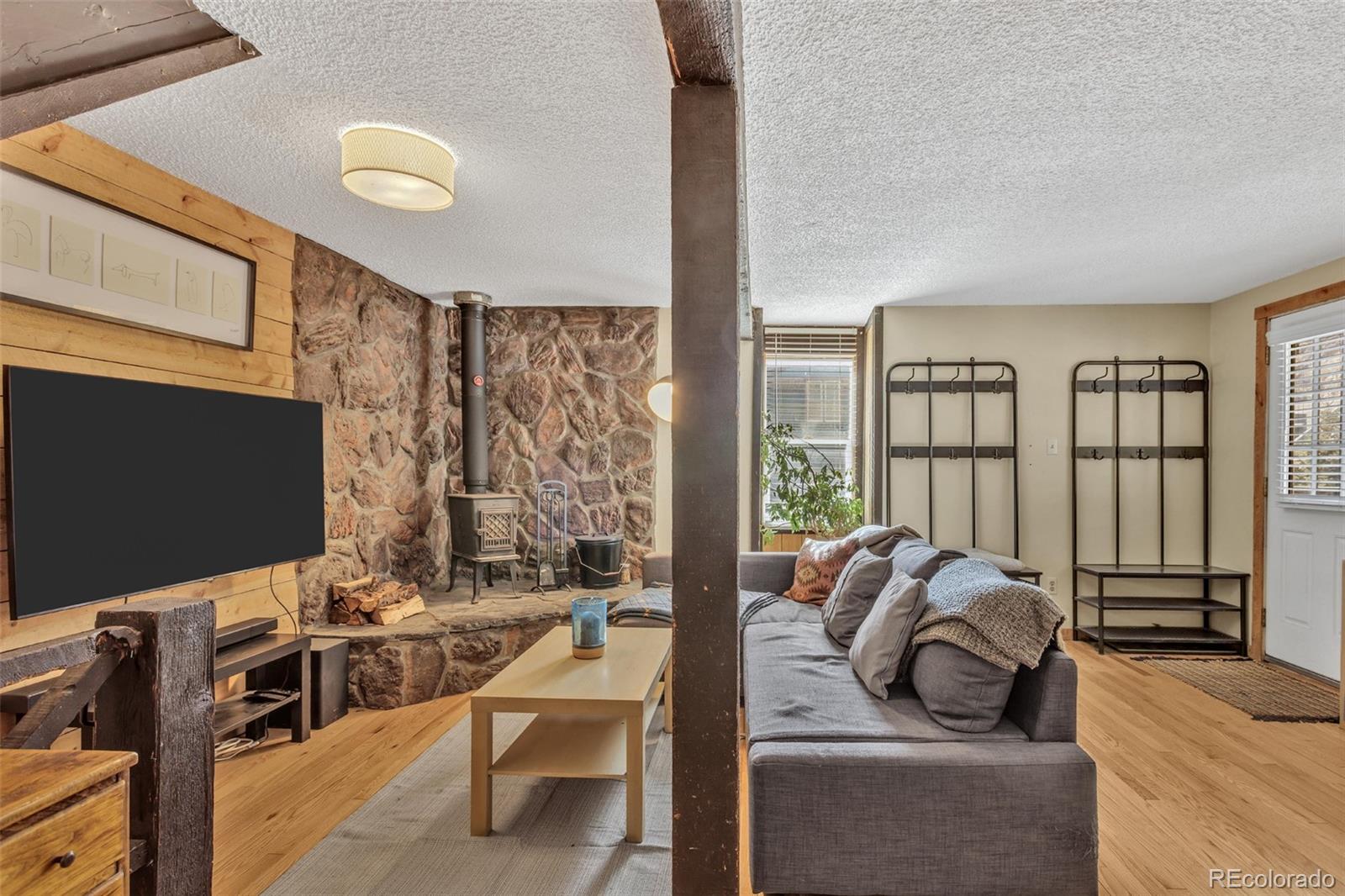 1450 Marion Street Georgetown, CO 80444 - Photo 3 of 25 a living room with furniture a flat screen tv and floor to ceiling window