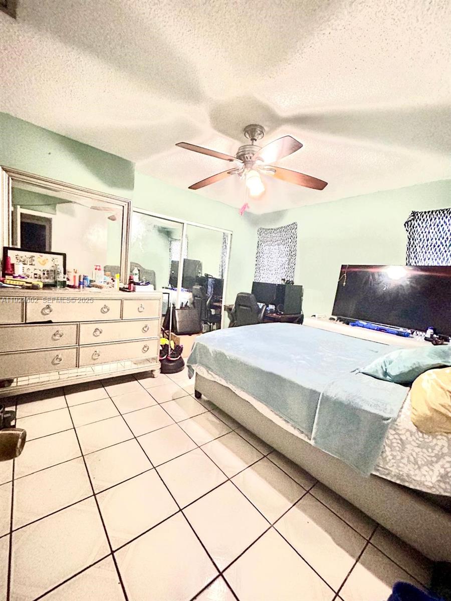 598 Southwest 121 Avenue Miami, FL 33184 - Photo 15 of 17 a bedroom with a large bed and a chandelier
