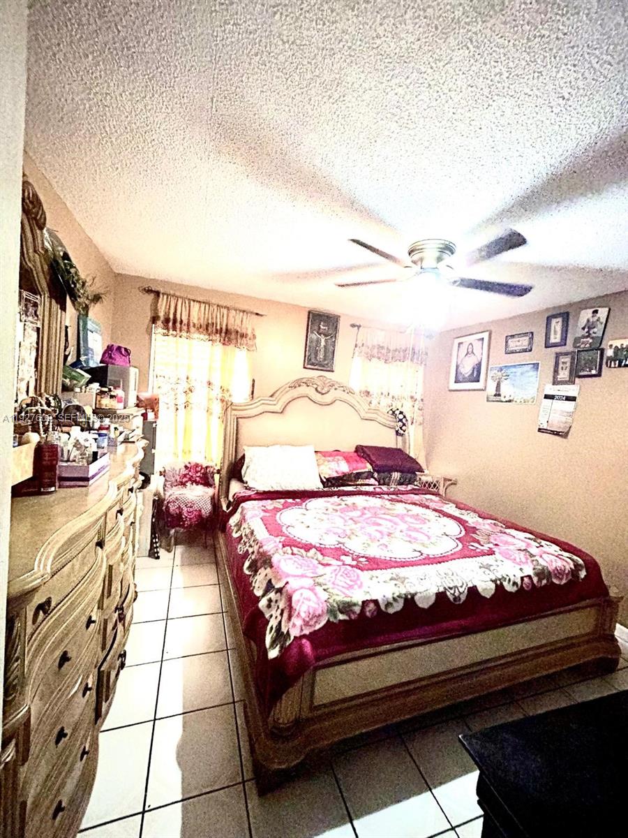 598 Southwest 121 Avenue Miami, FL 33184 - Photo 16 of 17 a bed room with a bed and a television