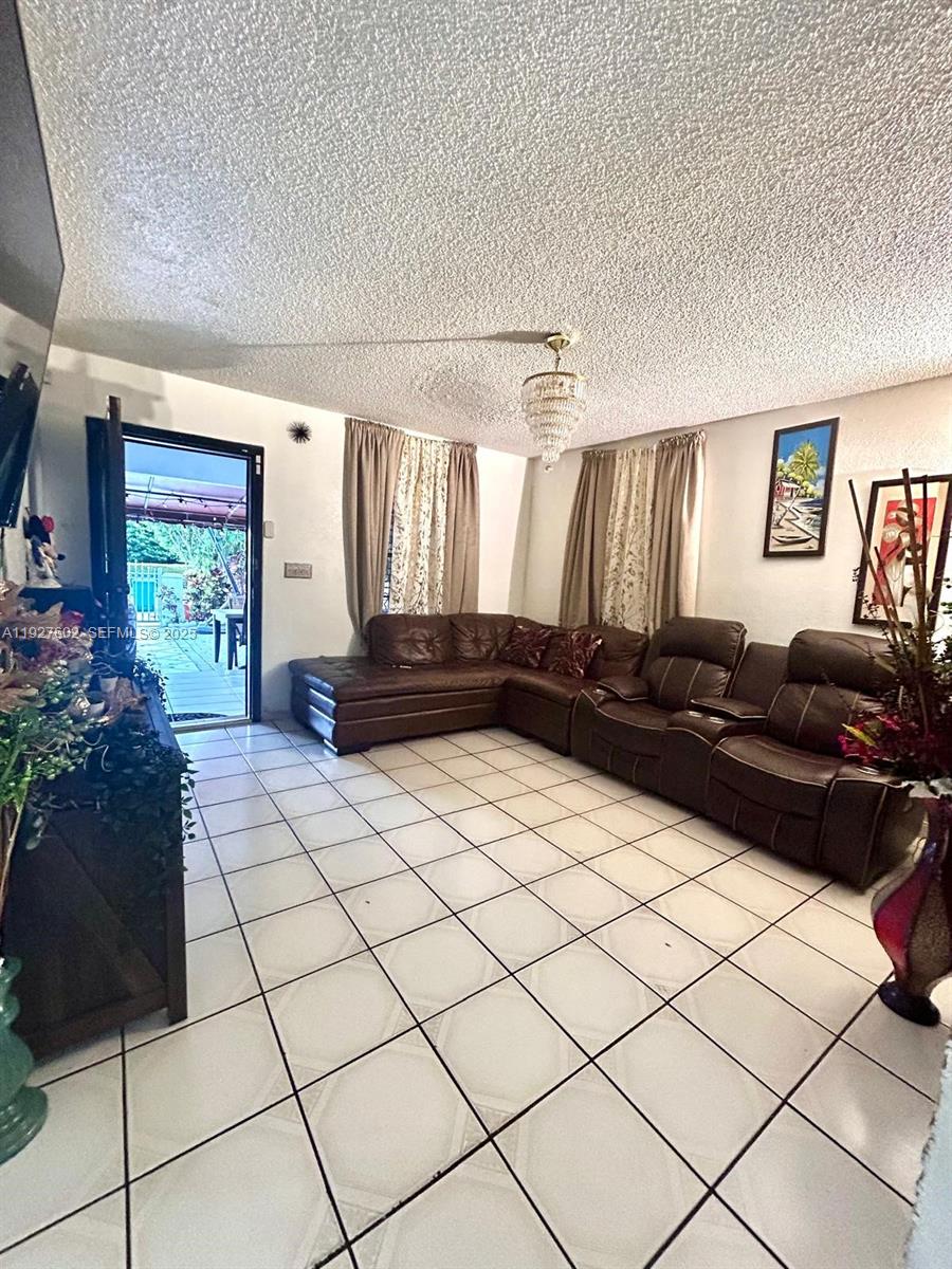 598 Southwest 121 Avenue Miami, FL 33184 - Photo 7 of 17 a living room with a couch and a potted plant