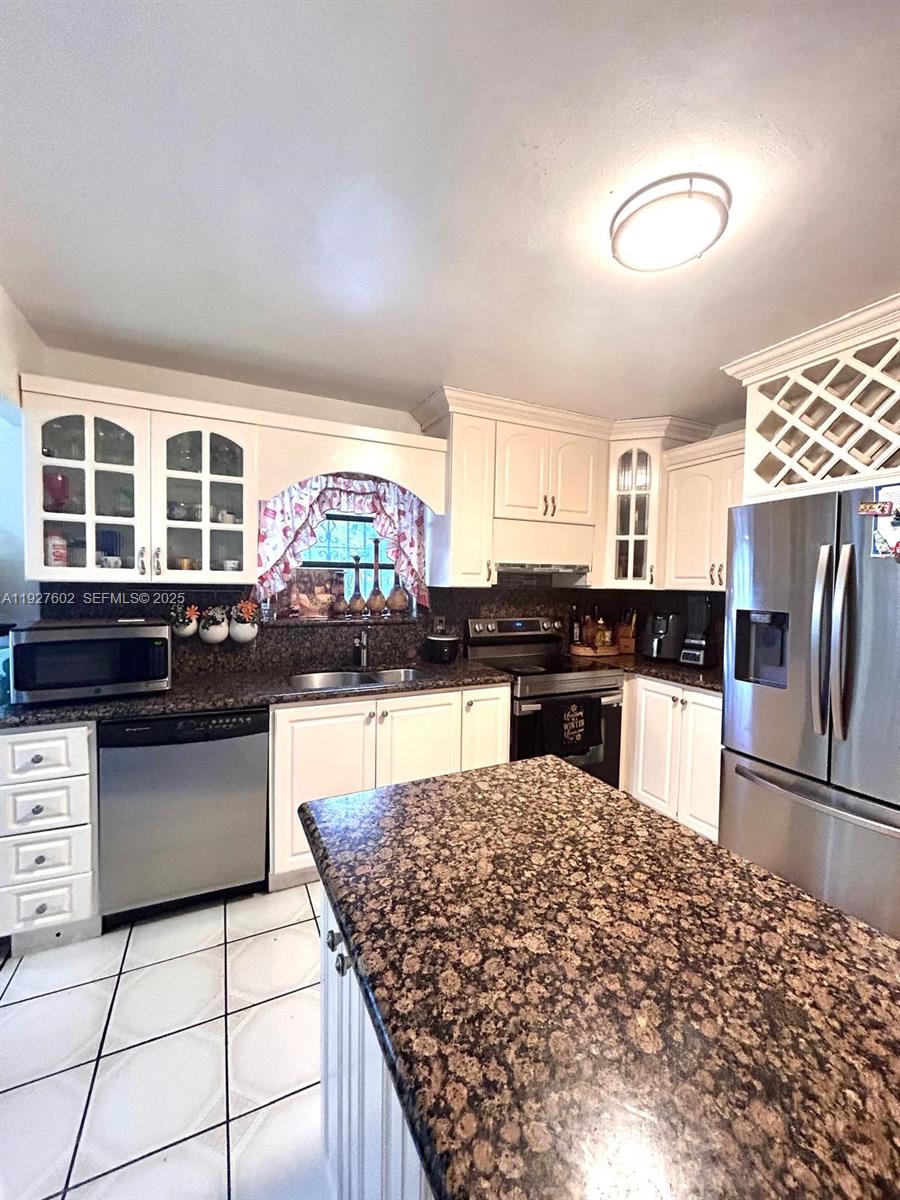 598 Southwest 121 Avenue Miami, FL 33184 - Photo 9 of 17 a kitchen with stainless steel appliances granite countertop a stove sink and cabinets