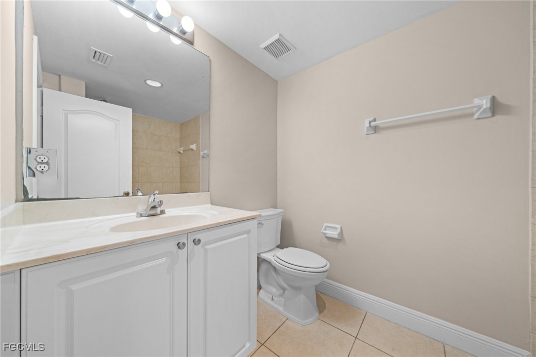 4172 Castilla Circle, Unit 101 Fort Myers, FL 33916 - Photo 14 of 37 a bathroom with a granite countertop sink a toilet and a mirror