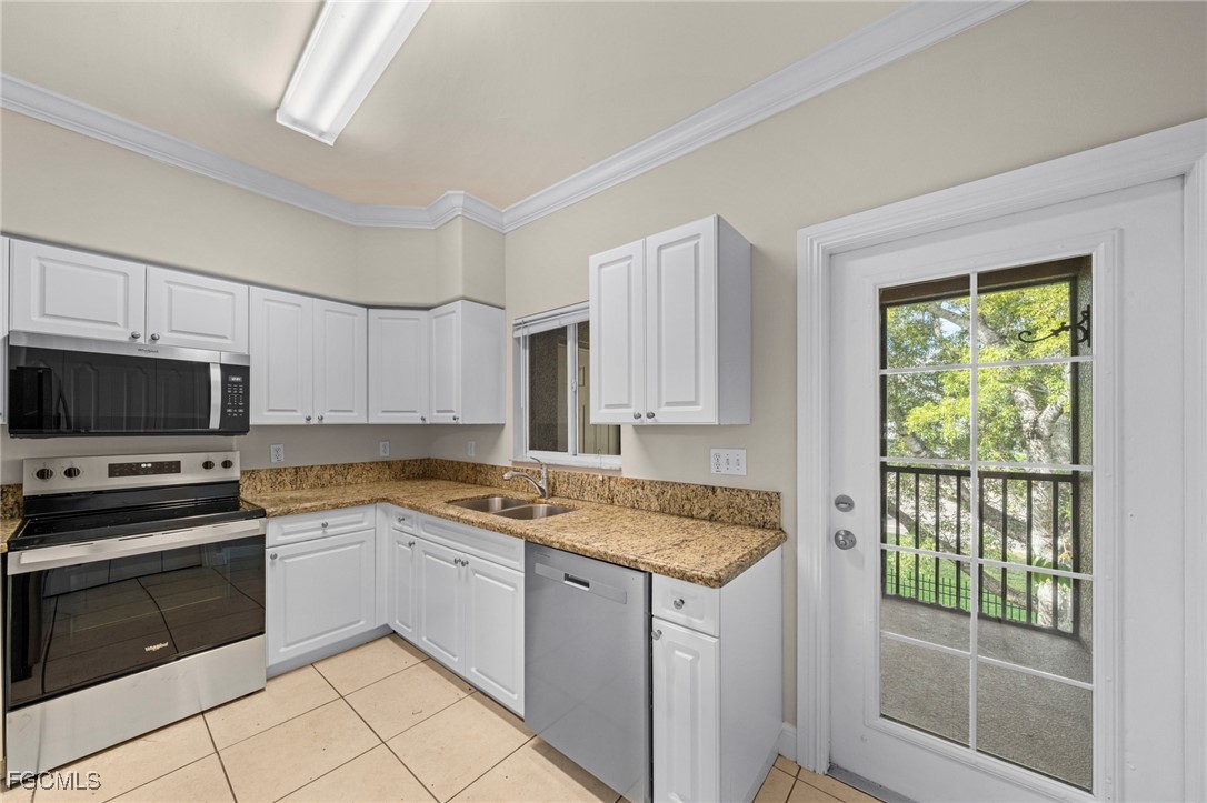 4172 Castilla Circle, Unit 101 Fort Myers, FL 33916 - Photo 6 of 37 a kitchen with a stove a sink and a microwave