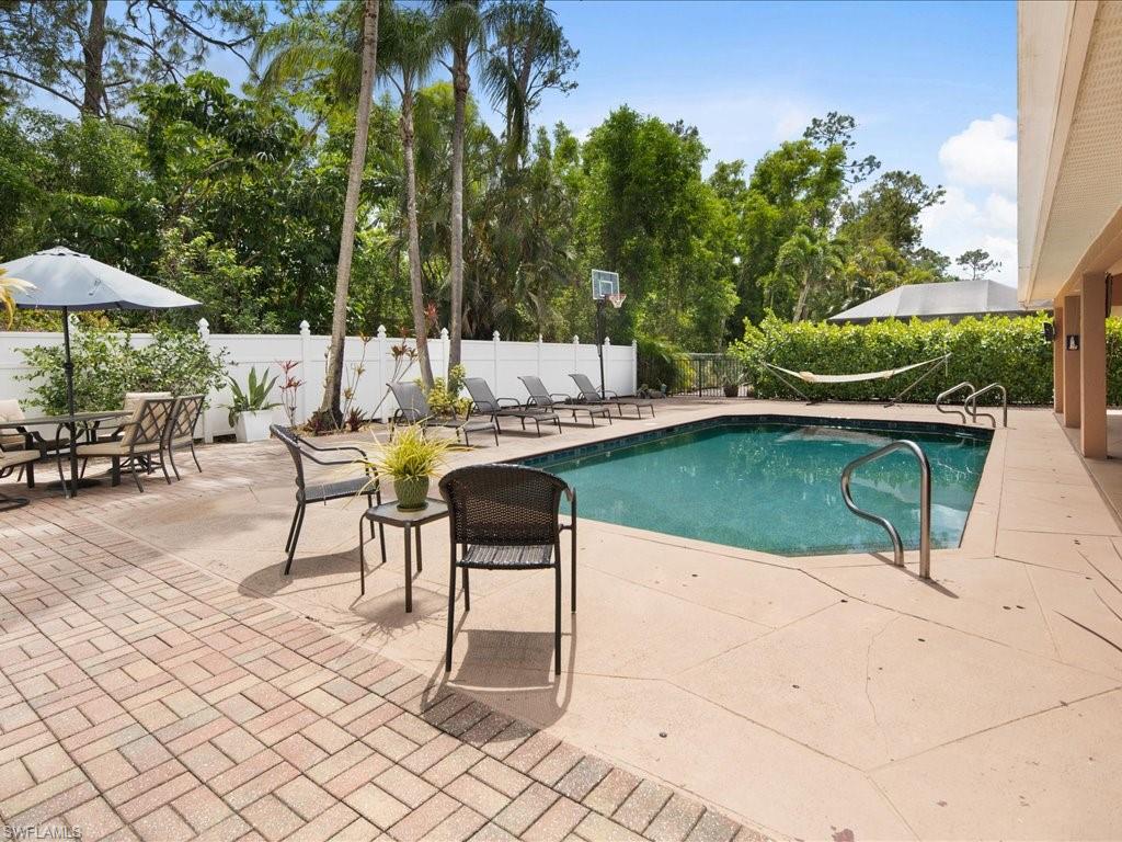 2088 Piccadilly Circus Naples, FL 34112 - Photo 1 of 29 a view of a patio with a table and chairs under an umbrella