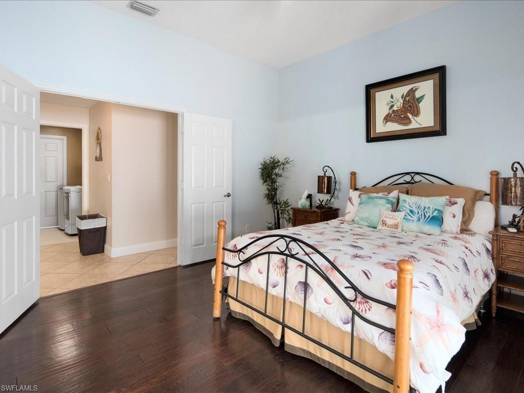 2088 Piccadilly Circus Naples, FL 34112 - Photo 13 of 29 a bedroom with bed and paintings on the wall