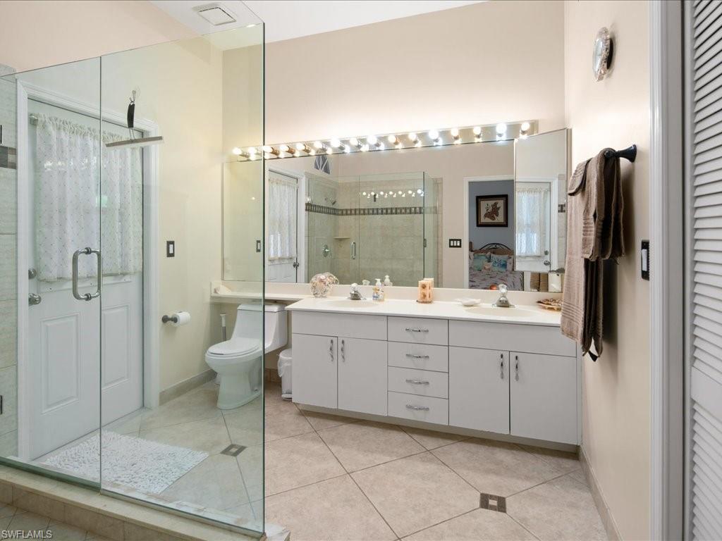 2088 Piccadilly Circus Naples, FL 34112 - Photo 14 of 29 a bathroom with a double vanity sink toilet and shower