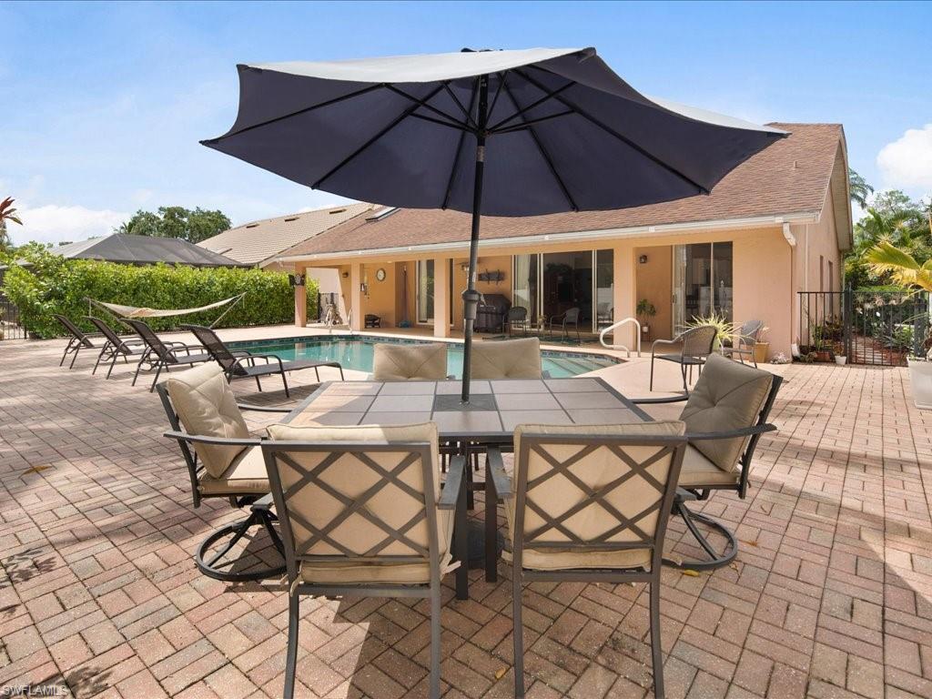 2088 Piccadilly Circus Naples, FL 34112 - Photo 27 of 29 a view of a patio with table and chairs under an umbrella