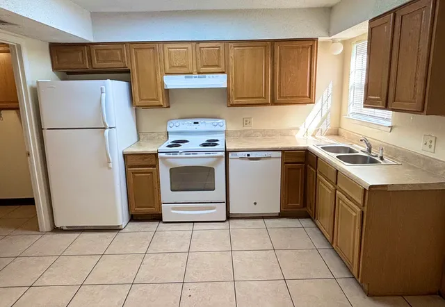 a kitchen with a stove sink and refrigerator