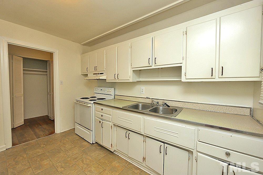 1109 North King Charles Road Raleigh, NC 27610 - Photo 11 of 13 a kitchen with stainless steel appliances granite countertop white cabinets and a sink