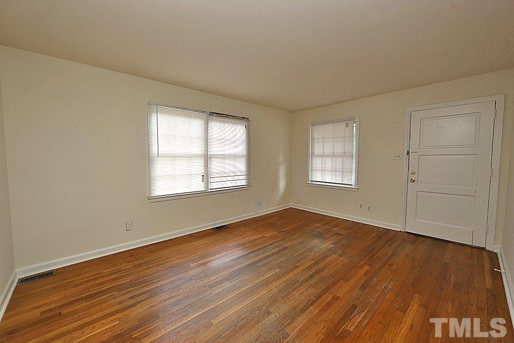 1109 North King Charles Road Raleigh, NC 27610 - Photo 3 of 13 an empty room with wooden floor and windows
