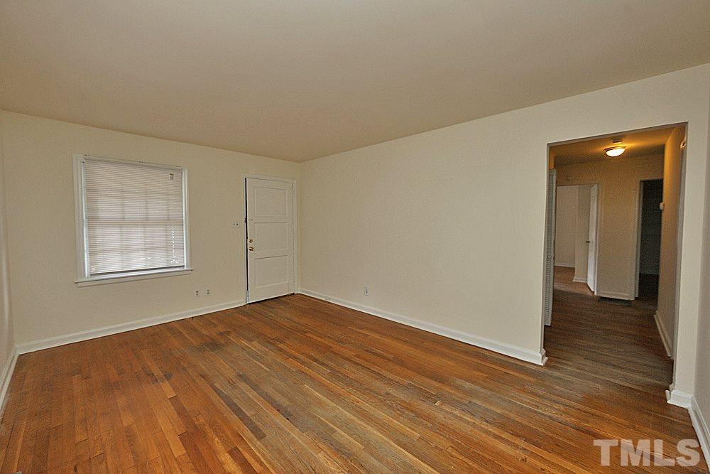 1109 North King Charles Road Raleigh, NC 27610 - Photo 4 of 13 a view of an empty room with wooden floor and a window