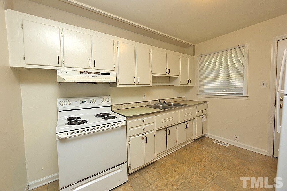 1109 North King Charles Road Raleigh, NC 27610 - Photo 5 of 13 a kitchen with granite countertop white cabinets and white appliances