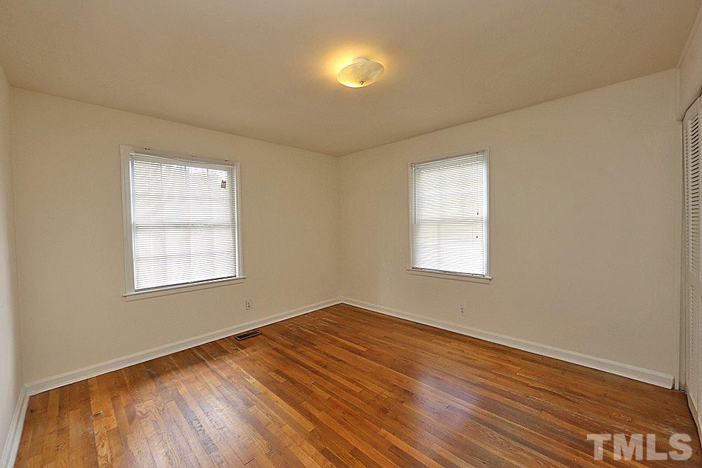 1109 North King Charles Road Raleigh, NC 27610 - Photo 9 of 13 an empty room with wooden floor and windows