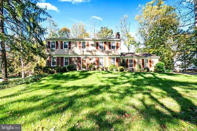 a view of a house with a big yard and large trees
