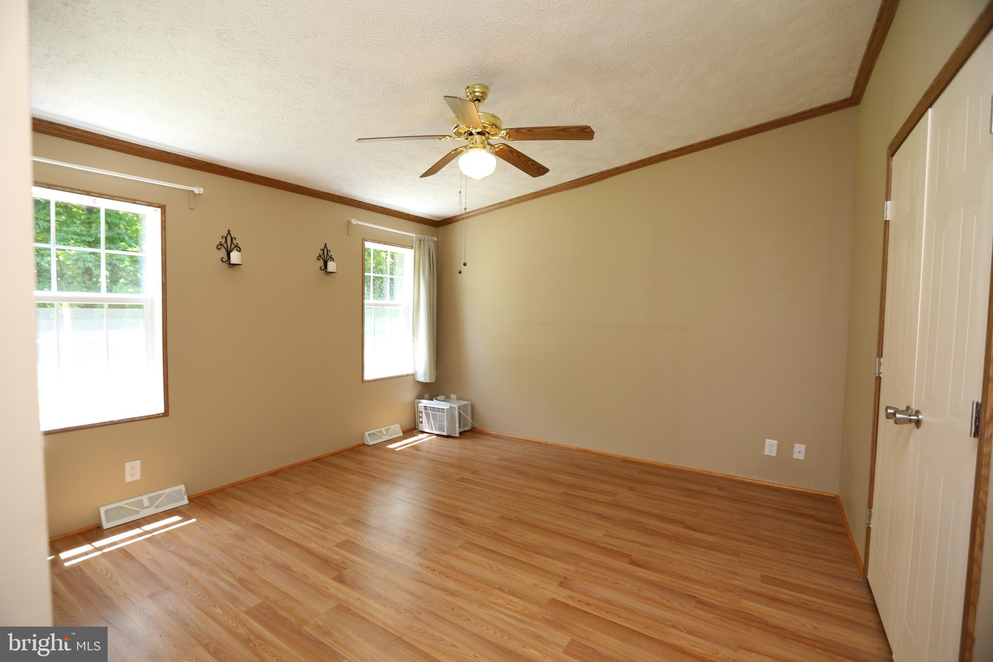 2439 Fairmount Road, Unit 11 Hampstead, MD 21074 - Photo 15 of 29 an empty room with wooden floor fan and windows