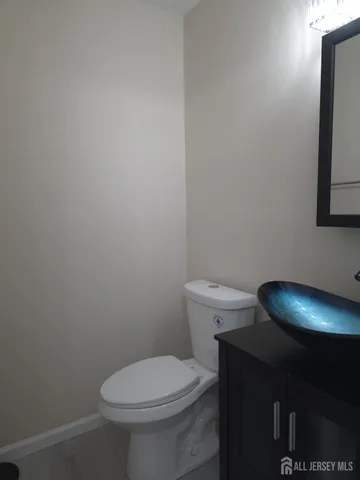 a toilet sitting in a bathroom next to a wooden wall