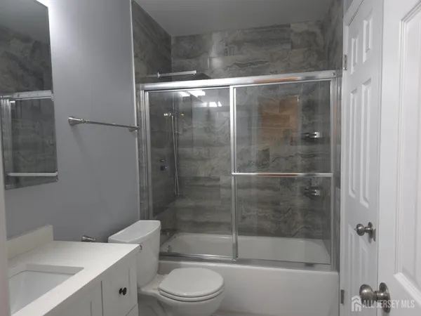 a bathroom with a shower a toilet and sink