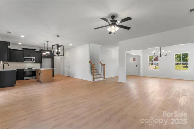 a view of a big room with wooden floor and windows