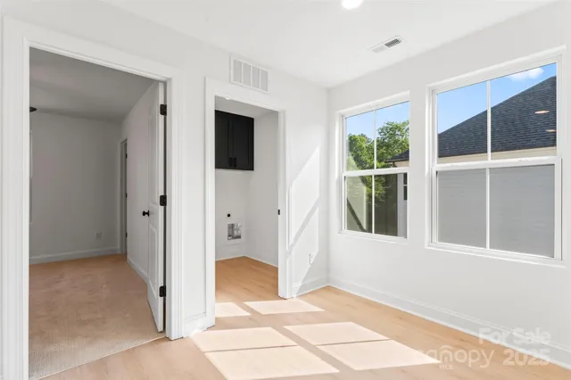a view of a hallway with windows and chandelier