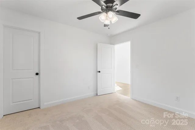 an empty room with a ceiling fan and a window