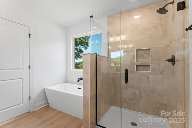 a view of a white house with a yard and table and chairs under an umbrella