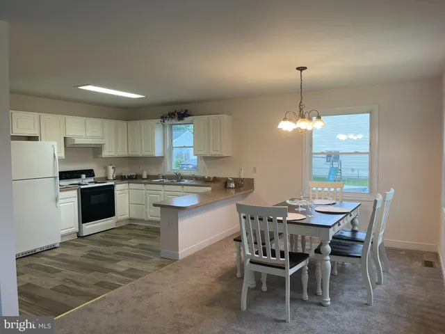 a kitchen with a dining table chairs stainless steel appliances and cabinets