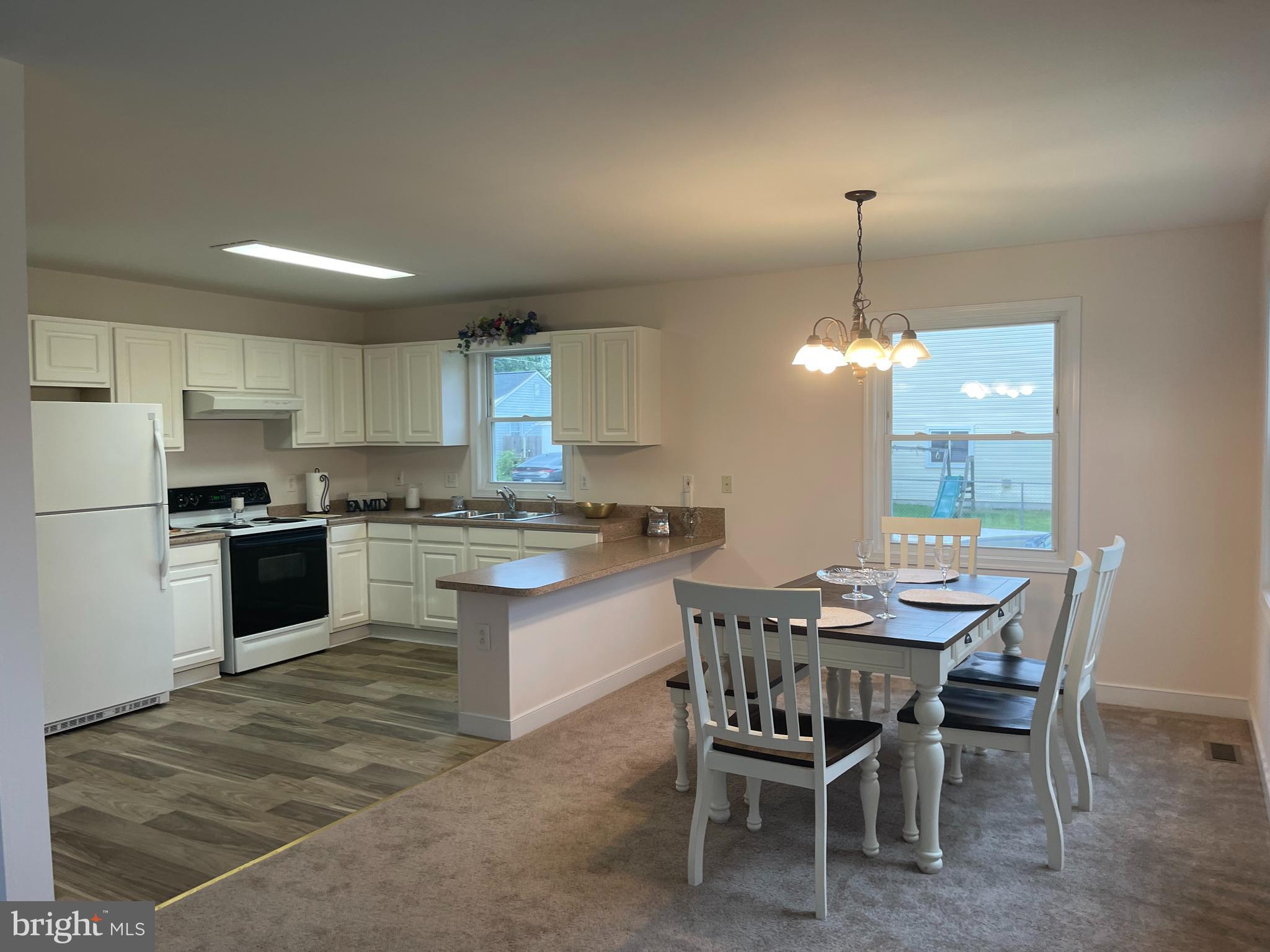 547 Compass Road East Middle River, MD 21220 - Photo 2 of 16 a kitchen with a dining table chairs stainless steel appliances and cabinets
