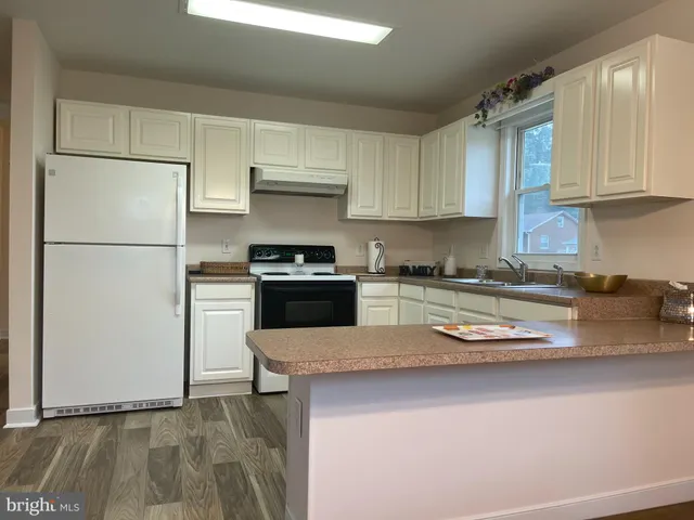 a kitchen with stainless steel appliances granite countertop a refrigerator sink and stove