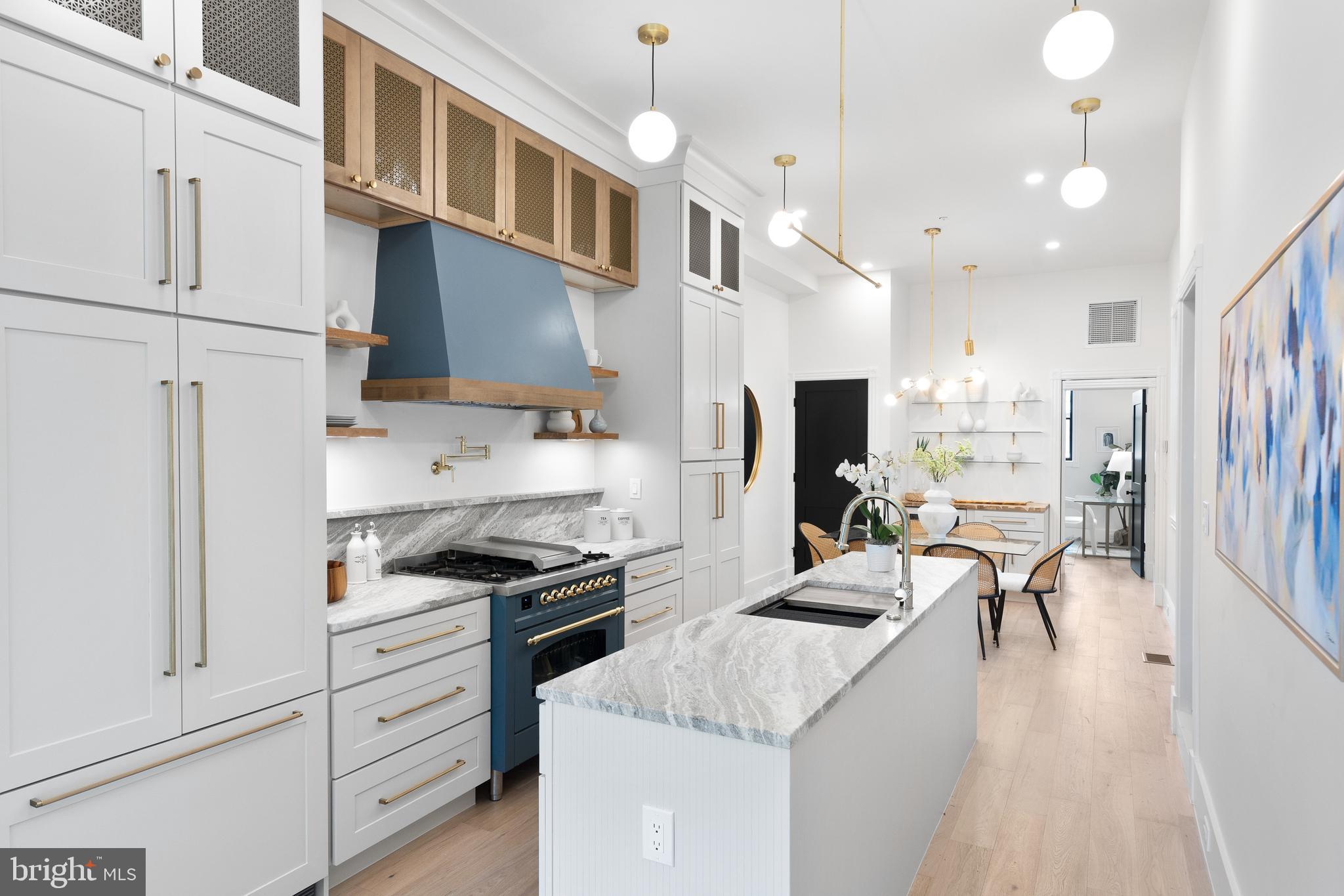 441 Q Street Northwest, Unit PH Washington, DC 20001 - Photo 11 of 55 a kitchen with stainless steel appliances kitchen island granite countertop a stove top oven a sink a refrigerator and white cabinets with wooden floor