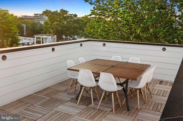 a view of a roof deck with couches and sky view