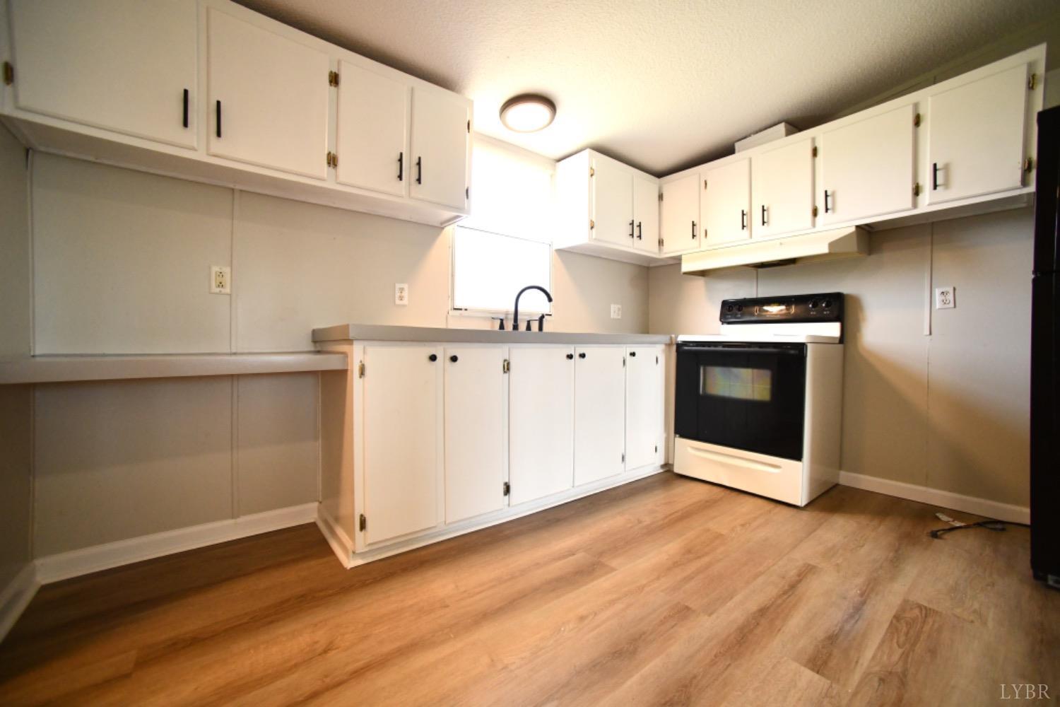 3961 Roark Mill Road Hurt, VA 24563 - Photo 14 of 28 a kitchen with stainless steel appliances granite countertop a stove a sink and white cabinets