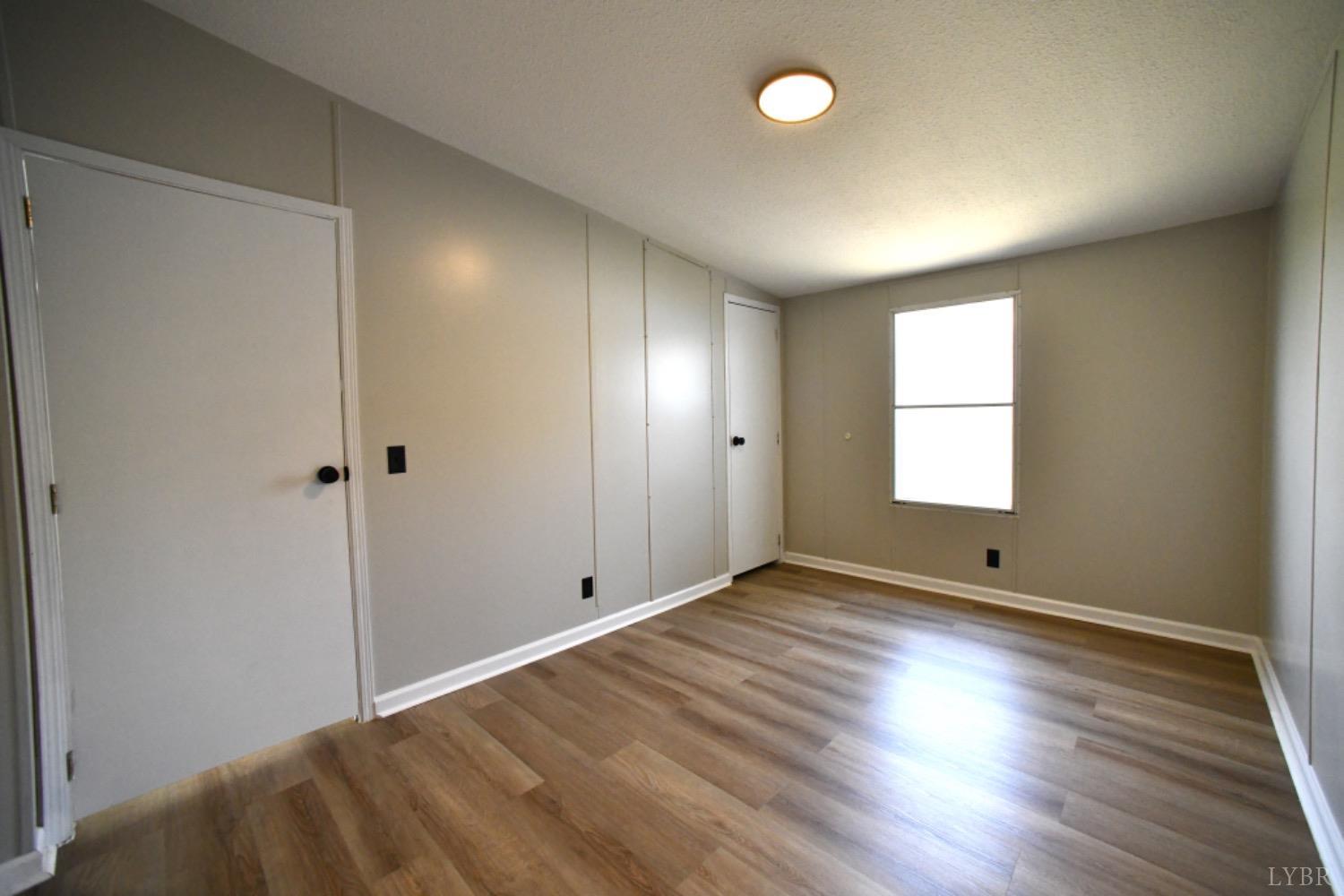 3961 Roark Mill Road Hurt, VA 24563 - Photo 25 of 28 an empty room with wooden floor and windows