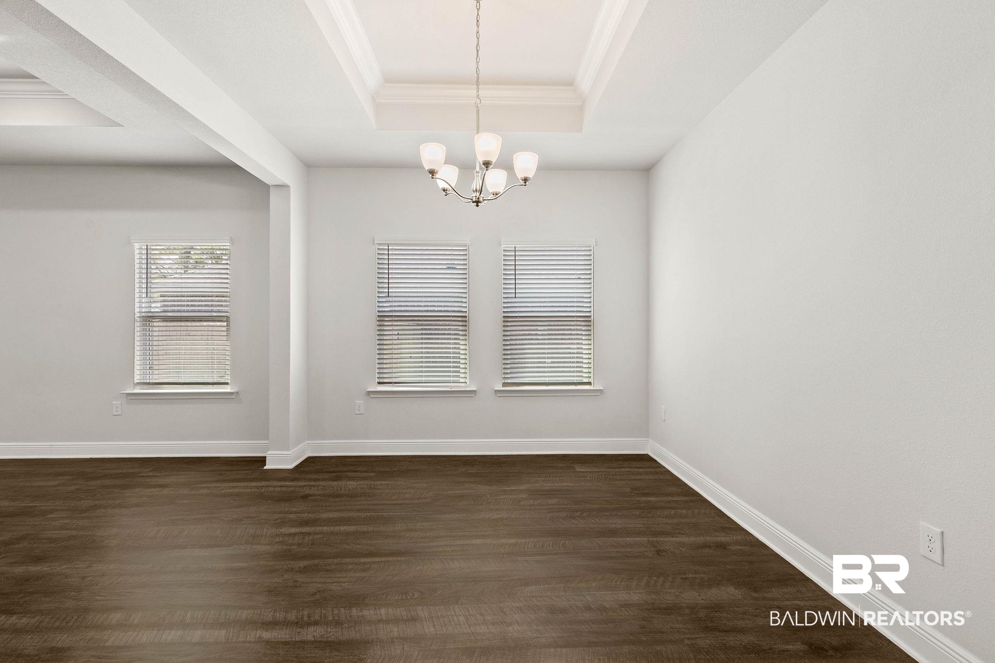 9448 Amethyst Drive Daphne, AL 36526 - Photo 14 of 61 Unfurnished dining area with a raised ceiling, hanging lights, dark wood-style floors, and ornamental molding