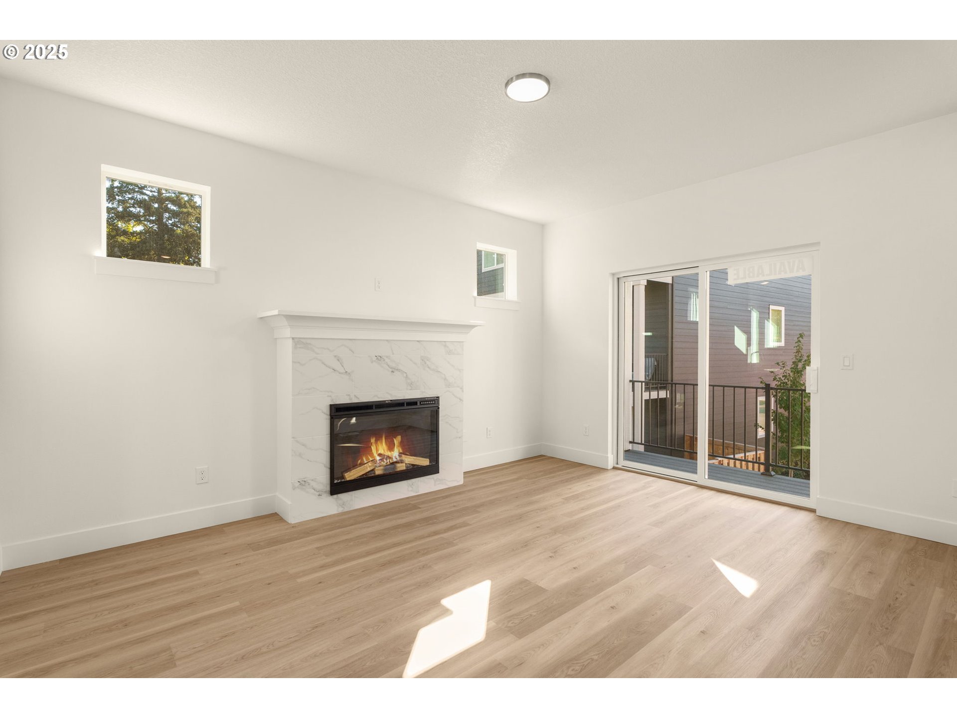 18933 Southwest Hazelwood Lane, Unit L9 Beaverton, OR 97078 - Photo 9 of 29 a view of an empty room with wooden floor fireplace and a window