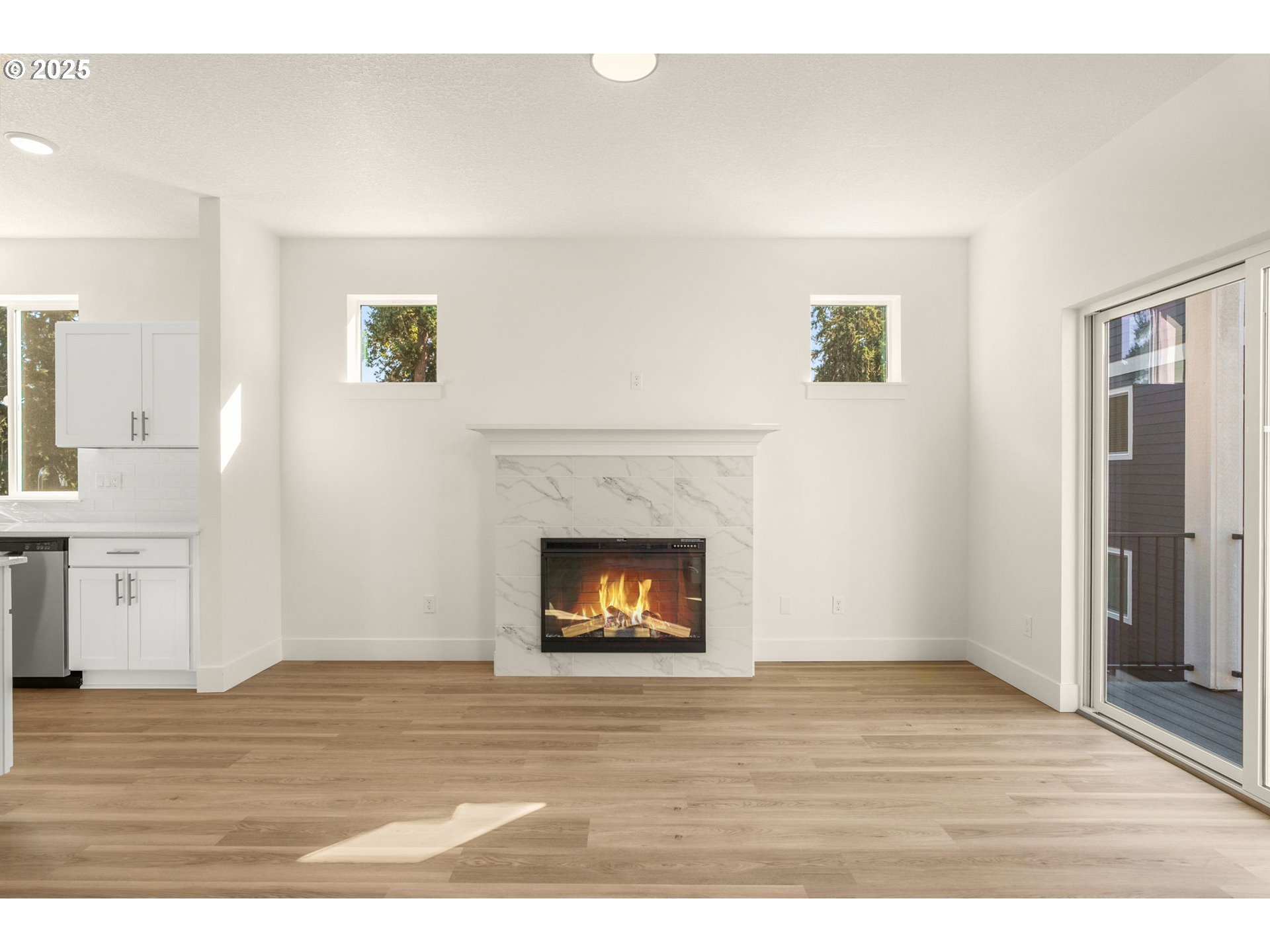 18933 Southwest Hazelwood Lane, Unit L9 Beaverton, OR 97078 - Photo 10 of 29 a view of an empty room with wooden floor and a fireplace