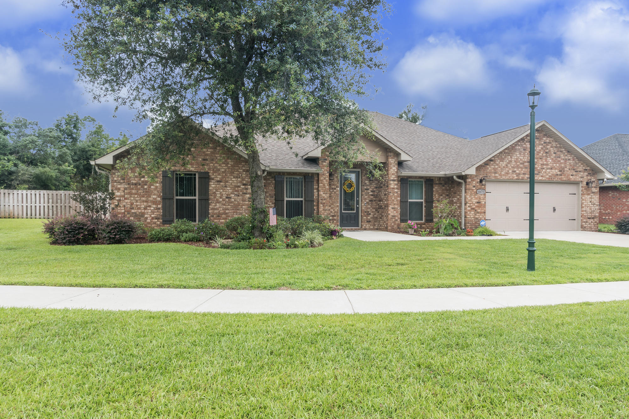 a front view of a house with a yard and trees