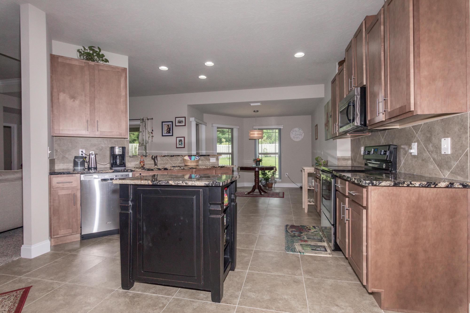 4675 Chanteuse Parkway Crestview, FL 32539 - Photo 12 of 35 a kitchen with stainless steel appliances granite countertop a stove top oven a sink dishwasher and a refrigerator with wooden cabinets