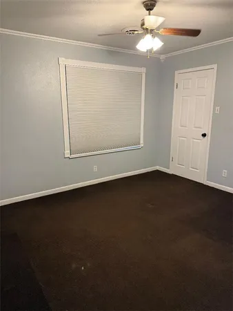 an empty room with a ceiling fan and a window