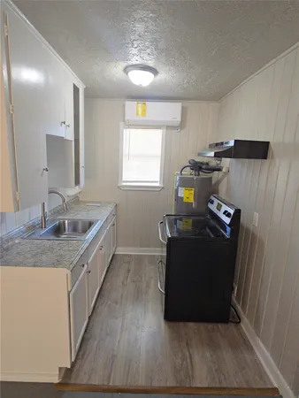 a kitchen with a sink and wooden floor