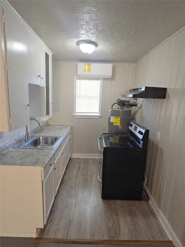 a kitchen with a sink and wooden floor