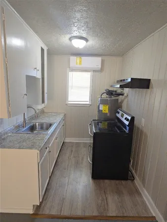 a kitchen with a sink and wooden floor