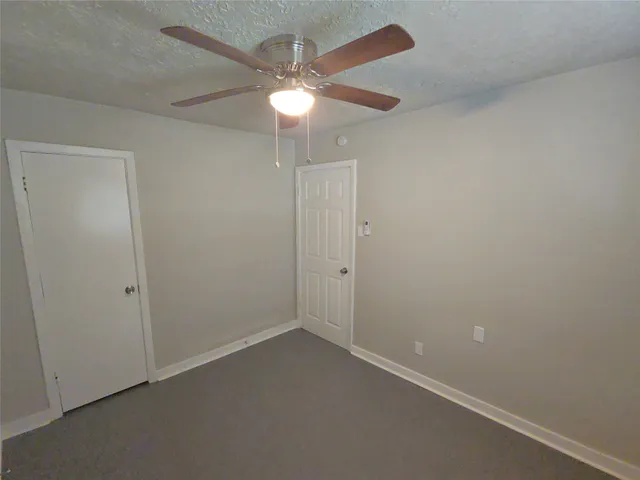 an empty room with a fan and a fan