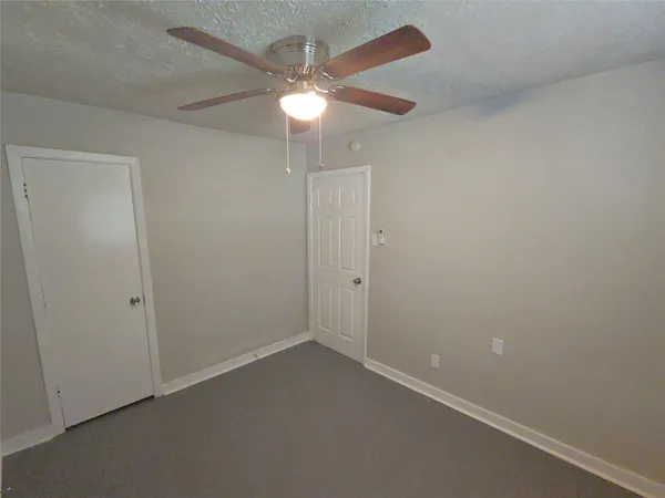an empty room with a ceiling fan and a fan