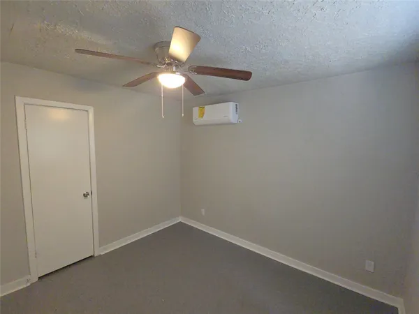 an empty room with a chandelier fan and a chandelier fan