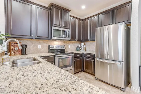 a kitchen with stainless steel appliances granite countertop a refrigerator and stove