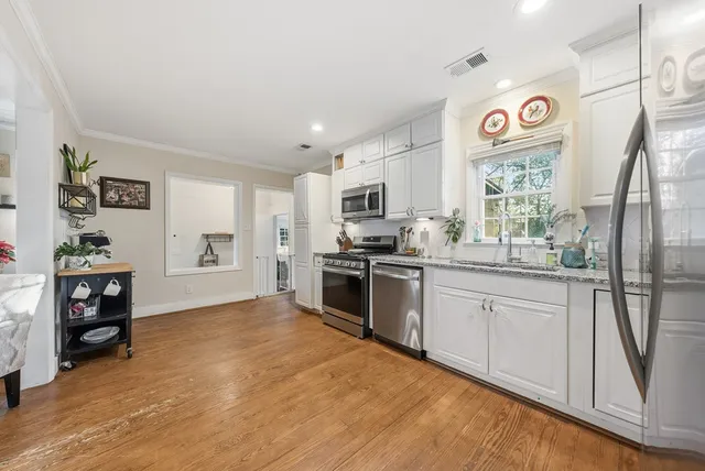 a kitchen with granite countertop a refrigerator and a stove top oven