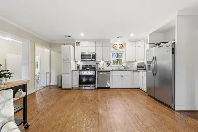 a kitchen with stainless steel appliances a refrigerator and a stove top oven