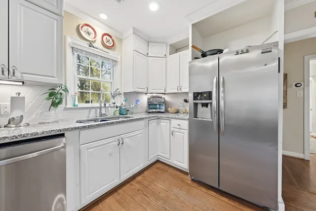 a kitchen with stainless steel appliances granite countertop a refrigerator and a sink